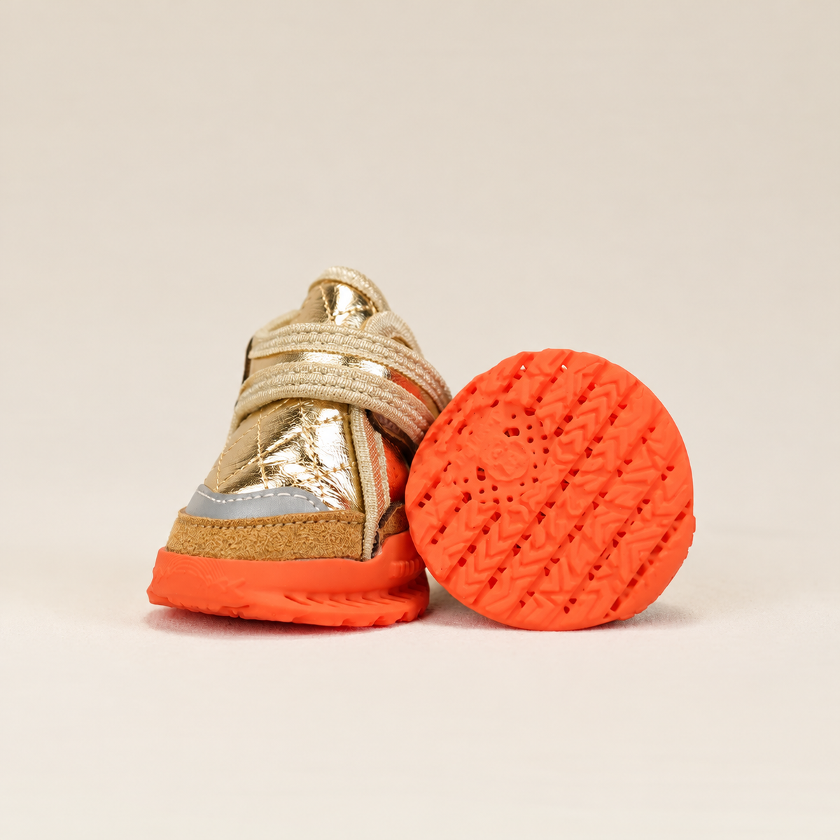 Metallic gold dog shoes with beige straps and orange ventilated soles